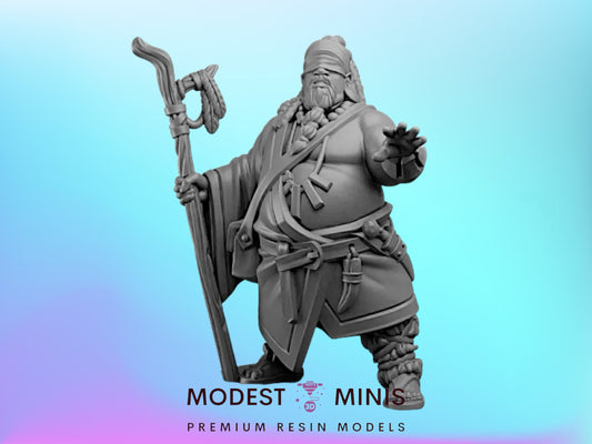 A statue of a man with a beard and a long beard, holding a staff and wearing a headdress, standing against a blue background.